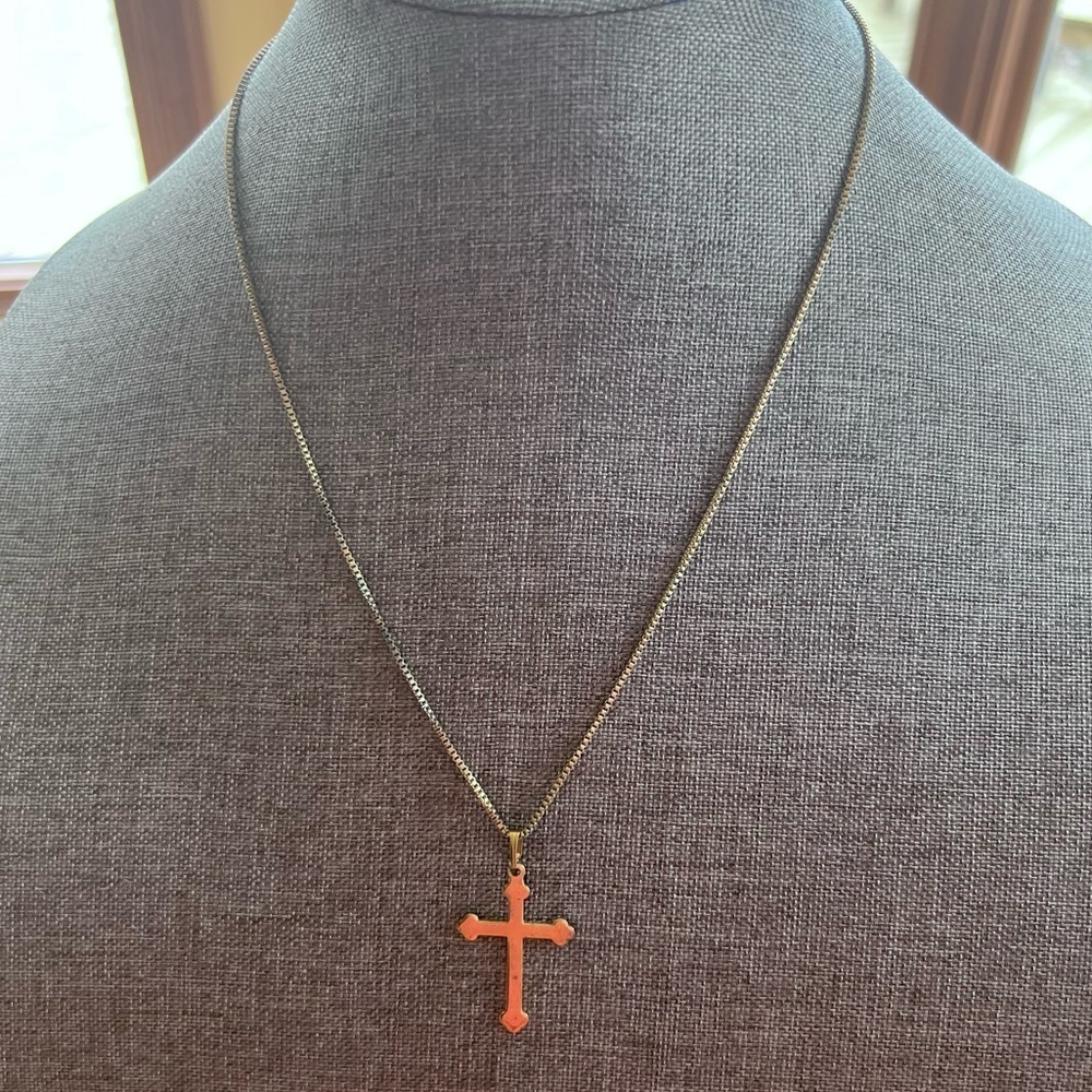 Gold tone cross pendant on gold tone chain